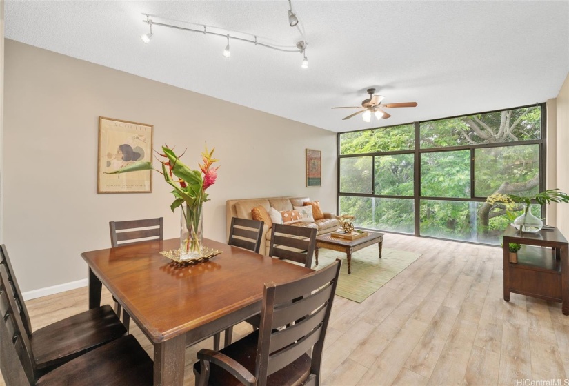 Open floor plan where dining area blends seamlessly with the living room. Notice the wall of windows which allows tons of sunlight in.