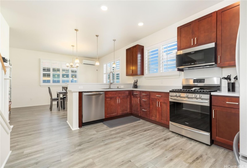 Kitchen with Stainless Steel appliances including a GAS stove leading to a second living area currently being used as a dining room