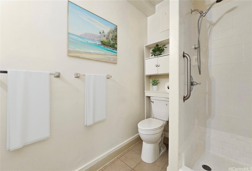 Virtually staged. Bathroom with a vanity sink on the opposite side (not shown on this photo) and ample storage.