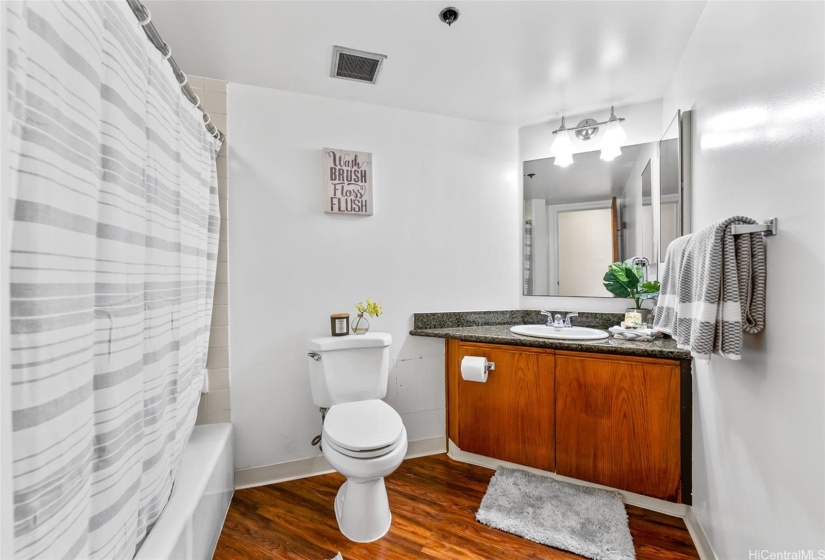 Spacious bathroom with luxury vinyl planks that match the kitchen flooring