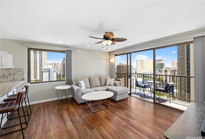 Open living area with luxury vinyl plank flooring and views of the ocean and Honolulu City Lights.