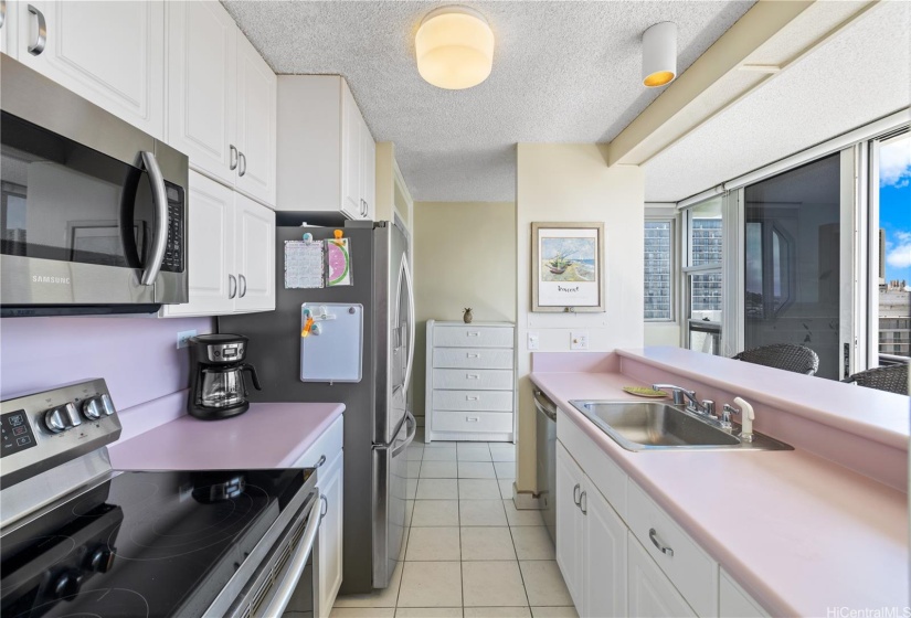 A full service kitchen with dishwasher and countertop seating.