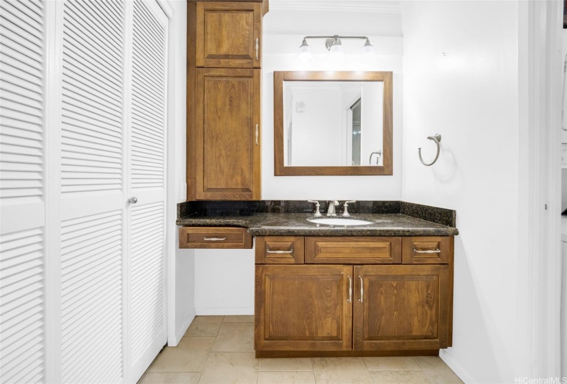 Remodeled bathroom has granite  countertops and ceramic tiles.