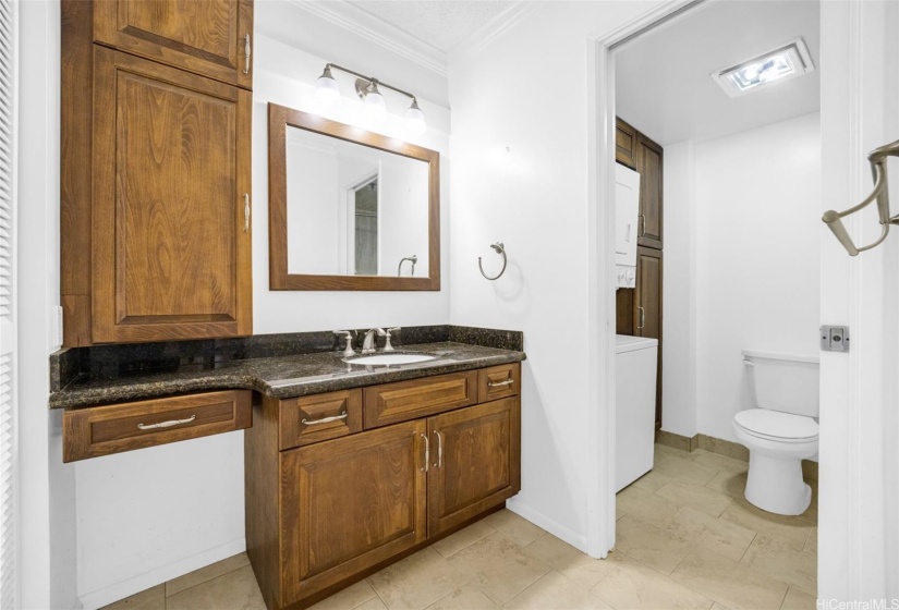 Remodeled bathroom has granite  countertops and ceramic tiles.