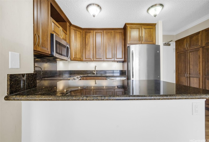 Remodeled kitchen has granite countertops.