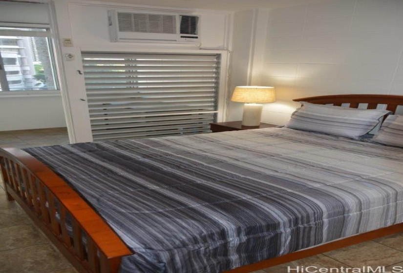 Bedroom with a/c unit and doorway to lanai