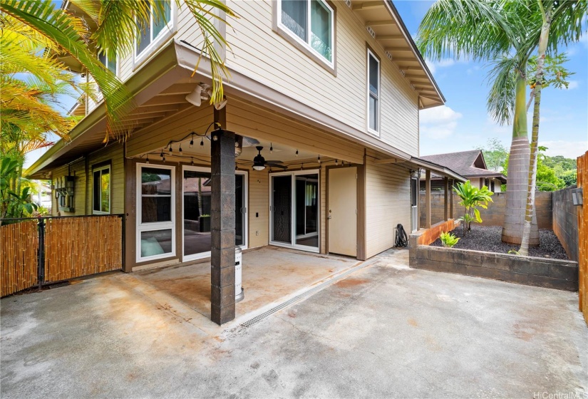 Rear exterior of home with a garden bed and room for entertaining.