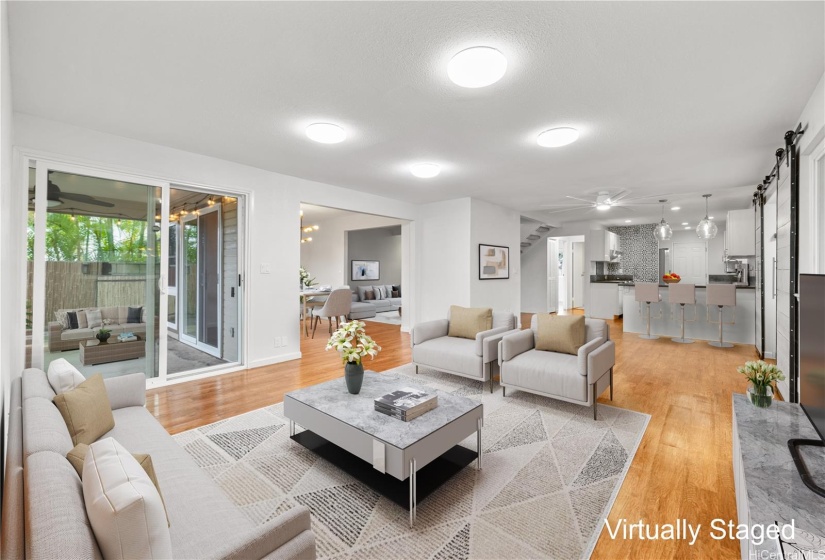 Spacious living room with access to outdoor patio.  The dining area and kitchen are in the back ground.