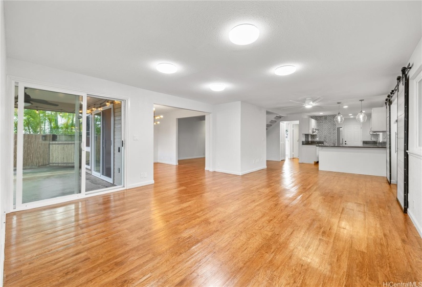 Spacious living room with access to outdoor patio.  The dining area and kitchen are in the back ground.