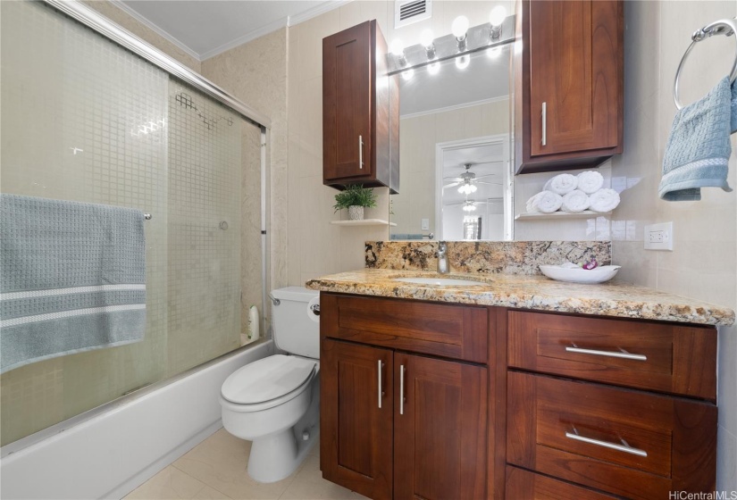 Primary Bedroom Bathroom features ceramic tiling throughout and an abundance of storage.