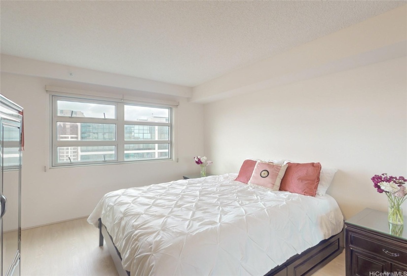 Spacious bedroom area with new window shades.