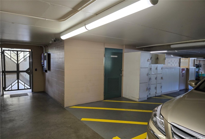 Same garage, opposite end of the Guest Parking is the garage entrance into the building accessed via a fob. To the right are storage lockers for bulky items from USPS. To the right of the lockers is Security.