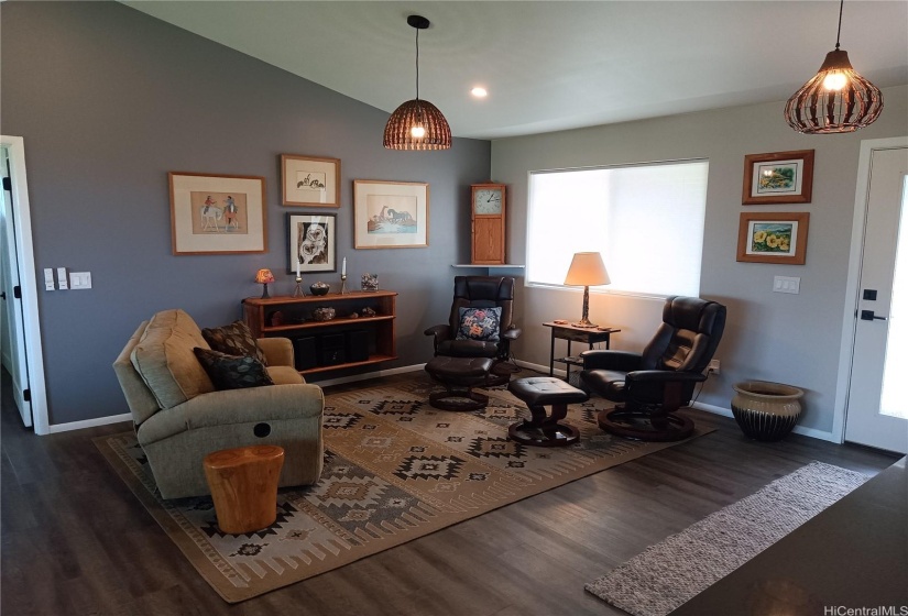 Image of living room with tan sofa on left and 2 dark reclining chairs on the right.