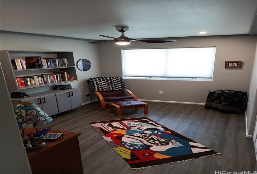 Bedroom / office #3 with a bookcase on far left, and a colorful rug on the floor.