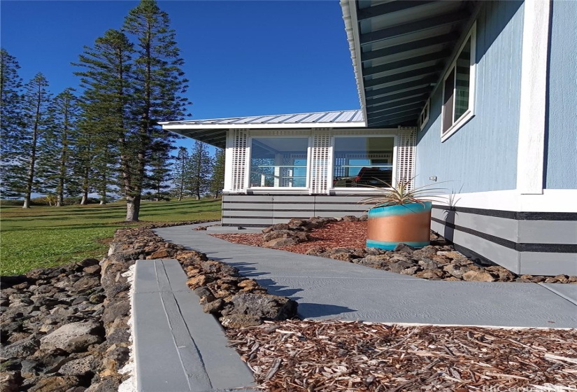 Exterior close up of home showing the sidewalk that circles the home.