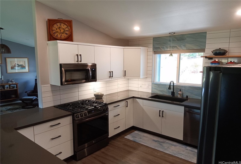 Kitchen close up, left side with oven and microwave.