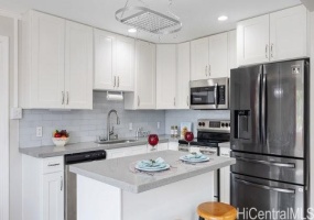 Beautifully renovated kitchen with modern tiled back splash.