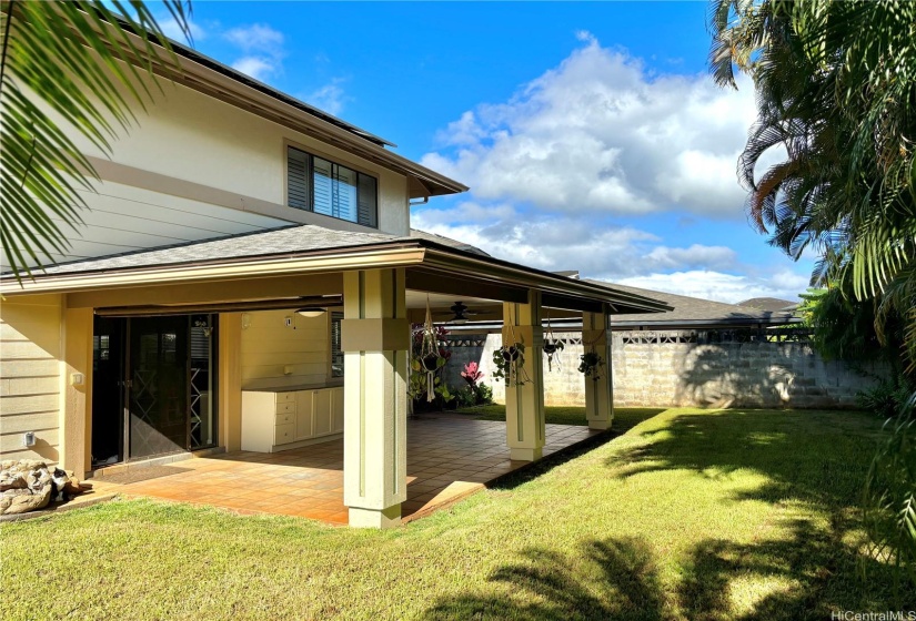 Beautiful landscaped backyard with tall palm trees for added privacy.