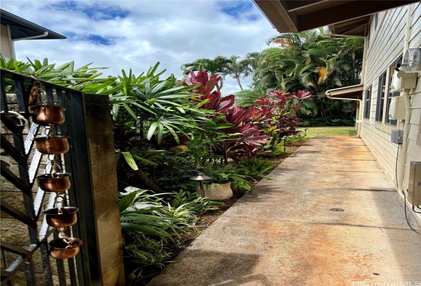 Gated side walkway with landscaped yard.