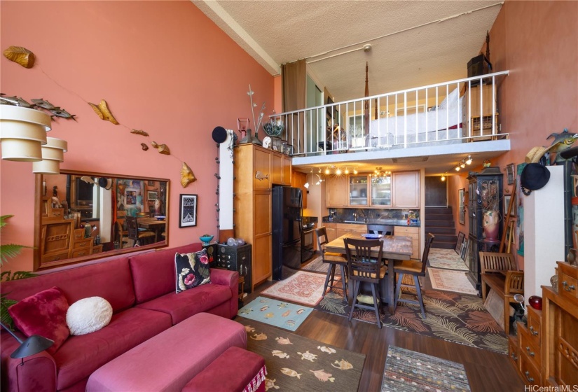 looking from living area to kitchen and front door and loft above