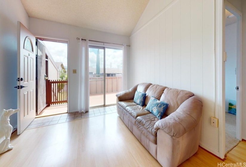 Another view of living room with sliding door opening outside to the large deck