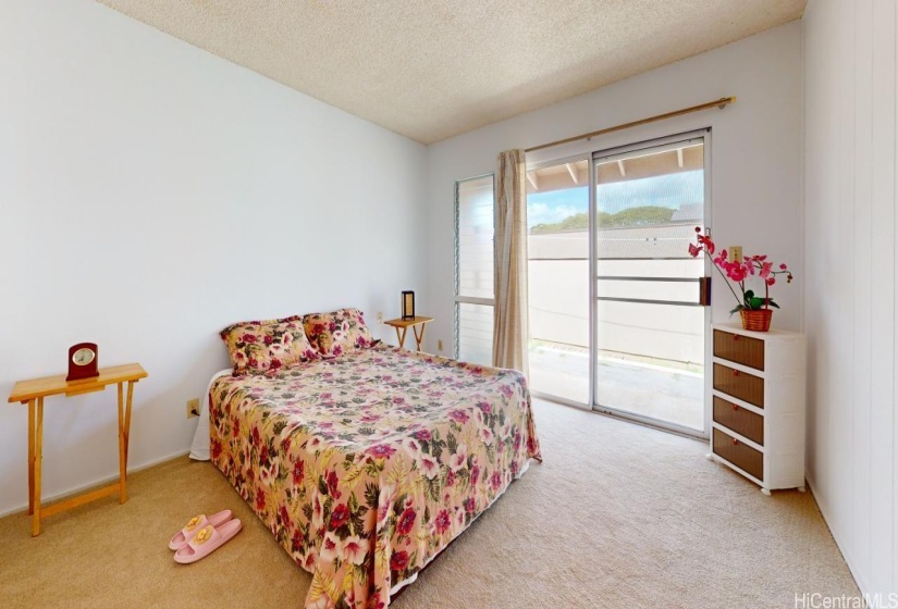 Primary bedroom with sliding door going outside to the patio