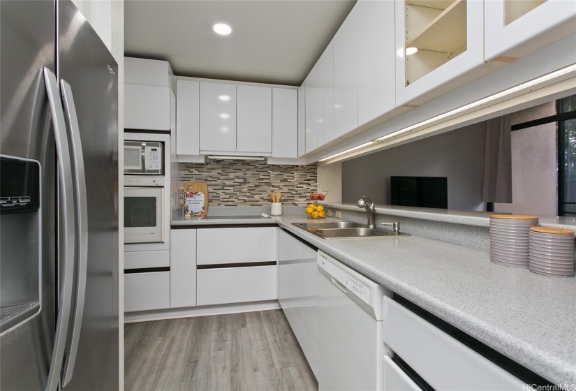 Galley kitchen with stainless steel refrigerator