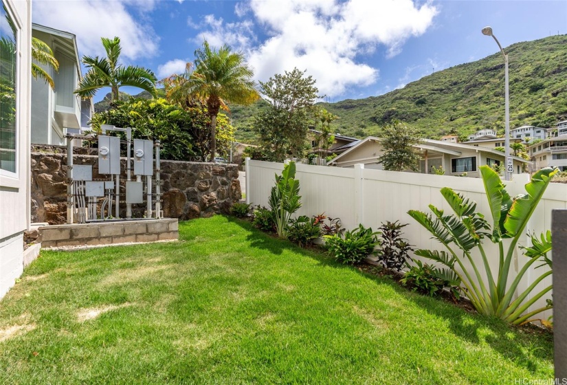 Front yard - manageable size for easy maintenance of lush landscaping + new vinyl fencing for privacy (and electric sub-meters).