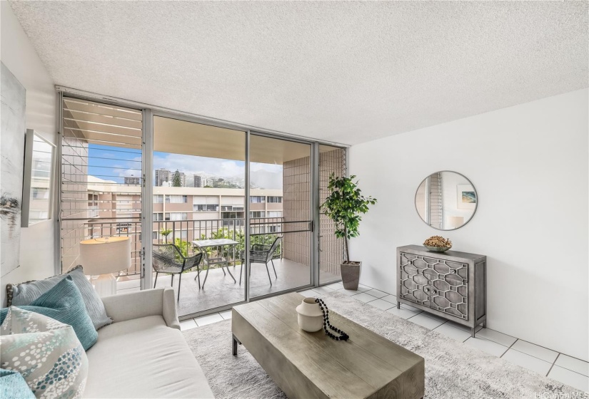 Spacious living room with balcony overlooking the landscaped courtyard.