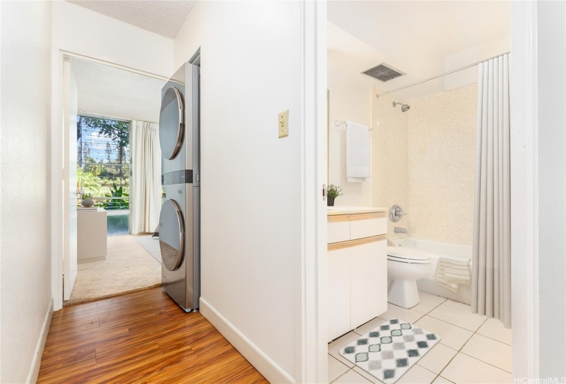 looking down hallway past washer/dryer to bedroom 2