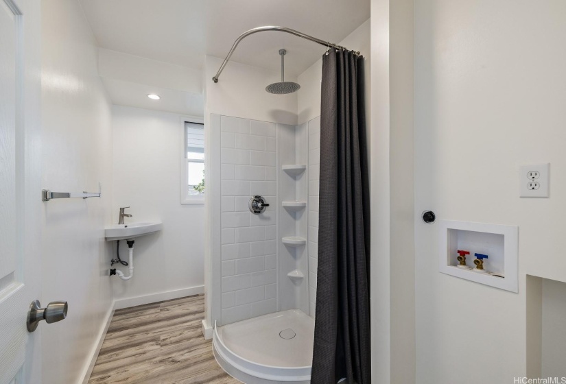 Bathroom in step down family room includes hook-ups for mini-stack washer/dryer.