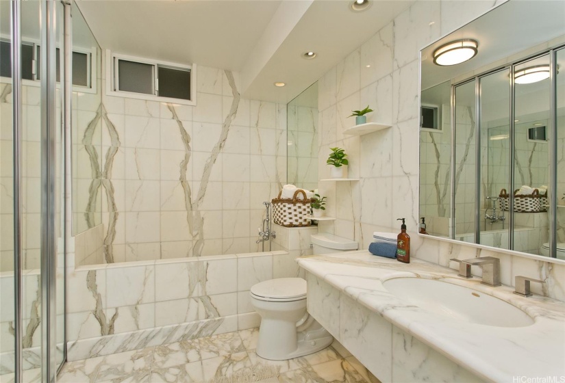 Beautiful bookmatched marble vein tiled soaking tub, large capacity stack Bosch washer/dryer and built in medicine cabinet.