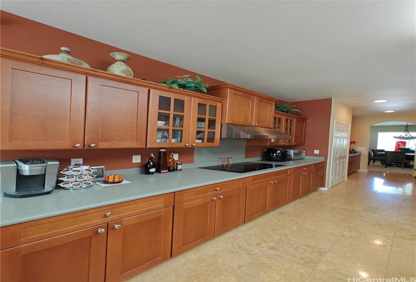 Long countertop and stove with lots of cabinet space looking towards the butler's alley and formal dining area.  The laundry area is on the right hand side.