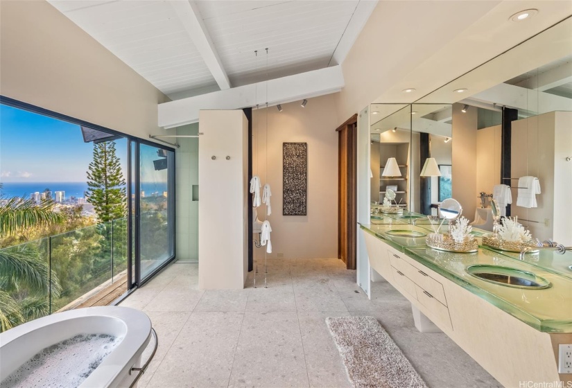 The total privacy of this ridgetop location allows you to have your bath in the open air with ocean views.  Custom glass countertops are out of this world.