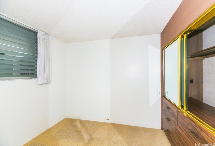 Bedroom nearest the living room and hallway, with built in closet and drawers.