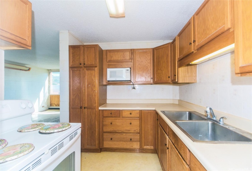 Range, refrigerator, microwave and washer in kitchen