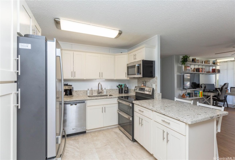 Updated Kitchen w/ new stainless steel double oven and ss appliances, quartz counters, white shaker cabinets, and ceramic tile.