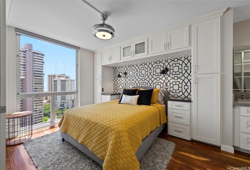 Primary bedroom with additional cabinetry and hand stenciled headboard nook.