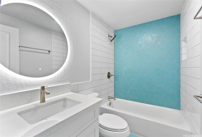 Fun hexagon shower accent wall with large backlit bathroom mirror.