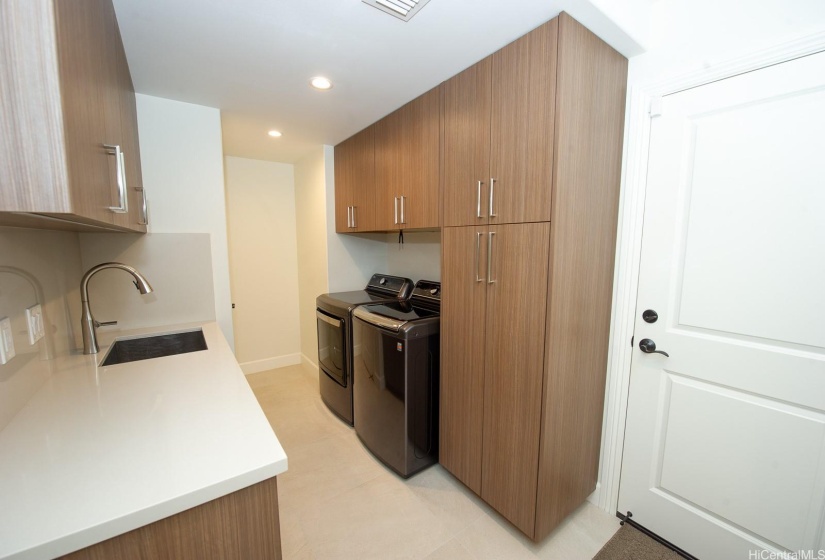 New laundry room with new large capacity washer and dryer. Hidden hanger rack right above them.