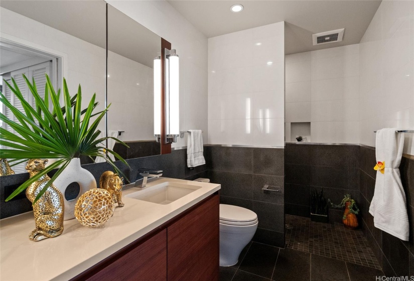 Double sink vanity, solid stone flooring and walk in shower stall --pure luxury.