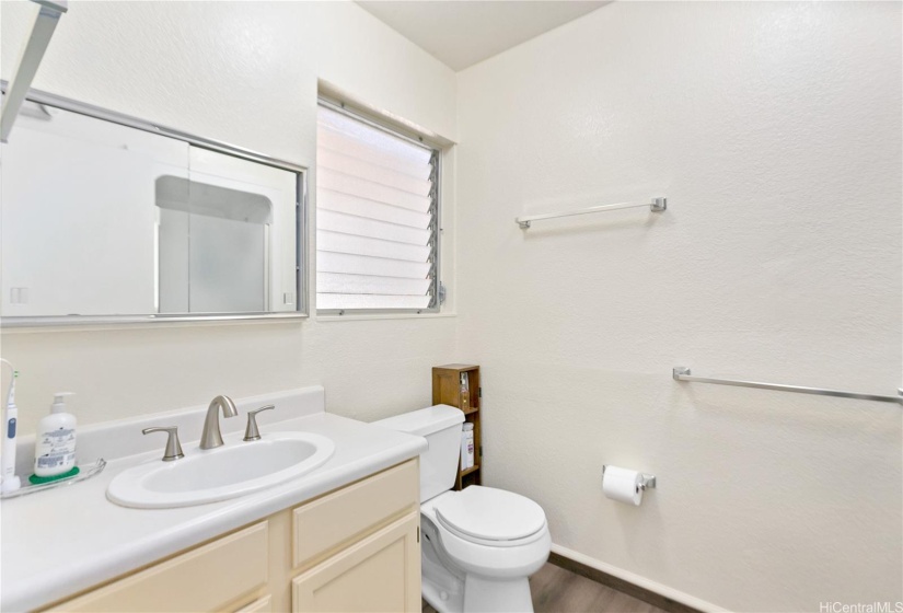 Full bath with walk-in shower across from toilet/sink area.