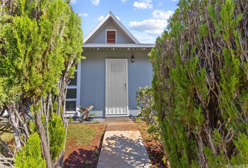 View of front door with security door, street parking possible on this side.