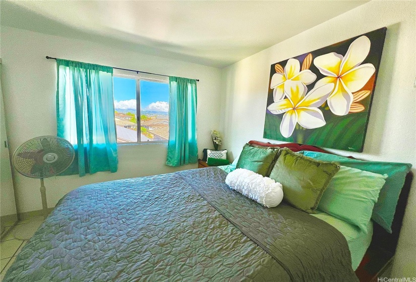 Enjoy Hawaiian breezes and mountain views from Bedroom #3 which exhibits different art and bedding to showcase tropical living.