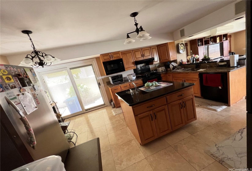 Kitchen area with access to outside.  Pellas Door with built in blinds, speakers (entertainment system), chandeliers.