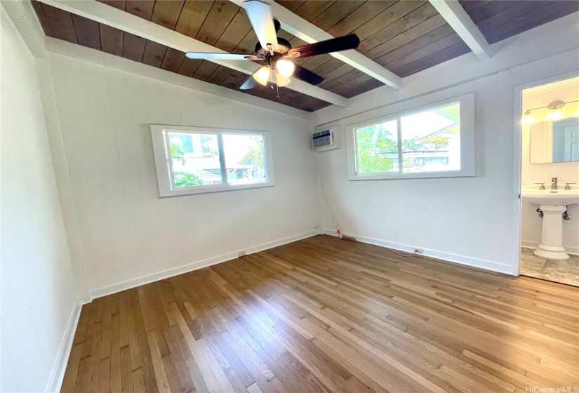 Main bedroom with window AC unit and ceiling fan with en suite.