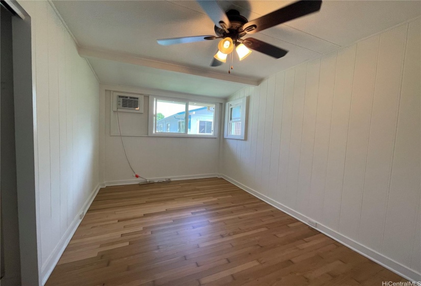 Bedroom 3 with window AC unit and ceiling fan.