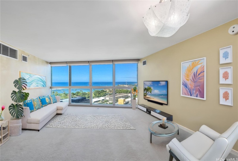 Virtually staged Living room with magnificent azure blue ocean in the daytime and golden sunsets in the evening.