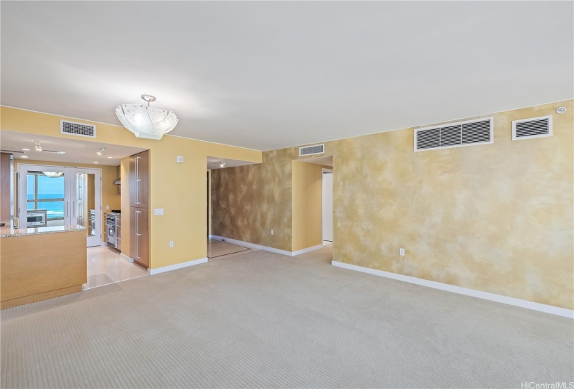 The large living room with custom accent wall offers a spacious beautiful space for your living and dining with striking views of the turquoise ocean.