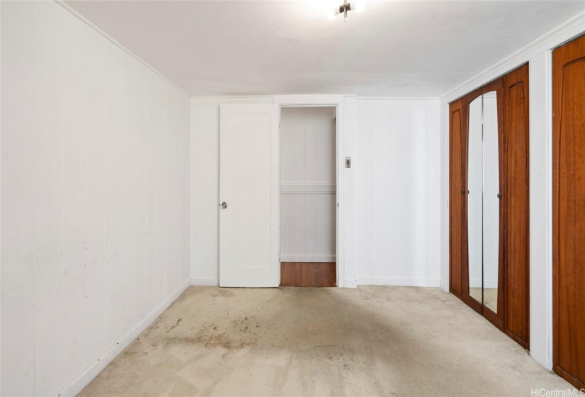 2nd level middle bedroom has hardwood floor under carpet, mirrored closet doors